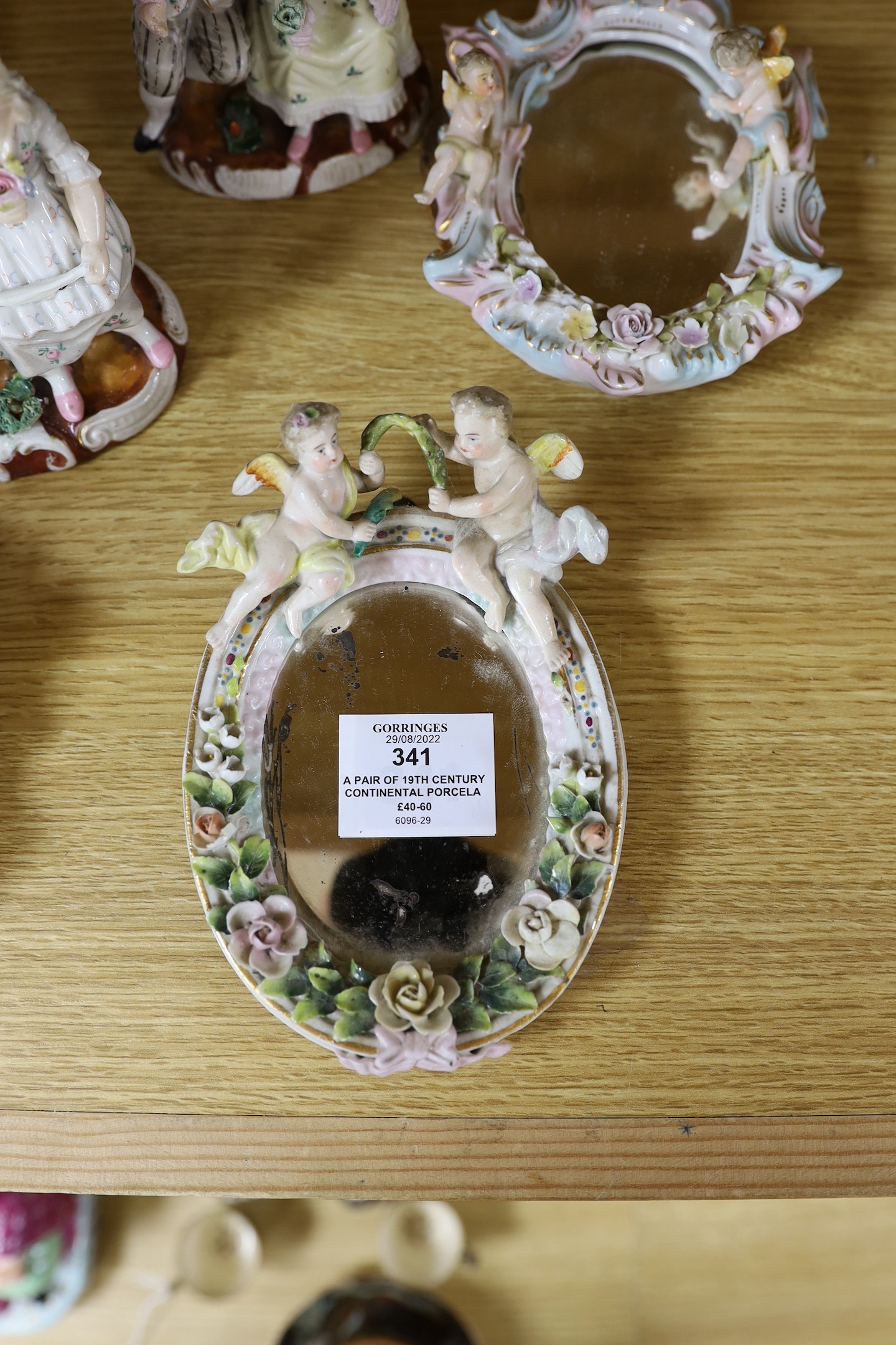 A pair of 19th century continental porcelain figural candlesticks and a group of four similar frames